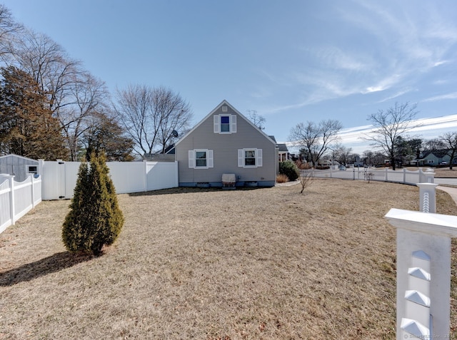view of side of property featuring a yard and a fenced backyard