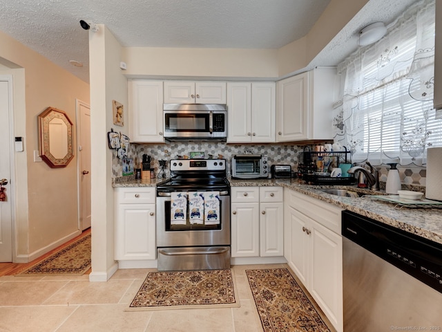 kitchen featuring white cabinets, stainless steel appliances, and a sink