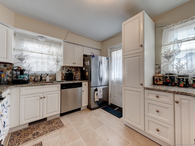 kitchen with visible vents, backsplash, appliances with stainless steel finishes, and white cabinets