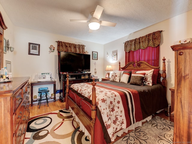 bedroom with a ceiling fan, light wood finished floors, and a textured ceiling
