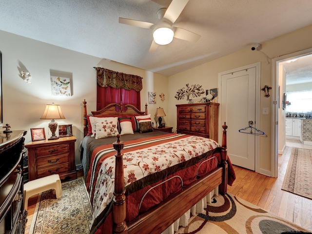 bedroom featuring baseboards, a ceiling fan, light wood-type flooring, and a textured ceiling