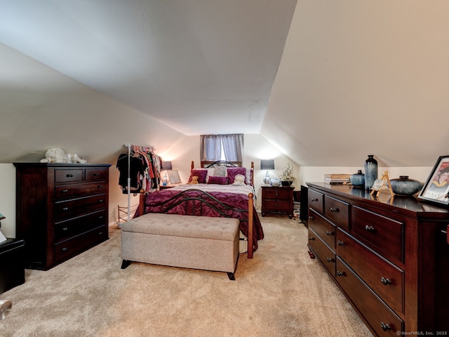 bedroom with lofted ceiling and light colored carpet