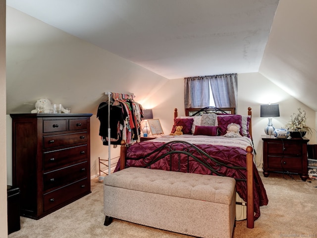 bedroom featuring vaulted ceiling and light carpet