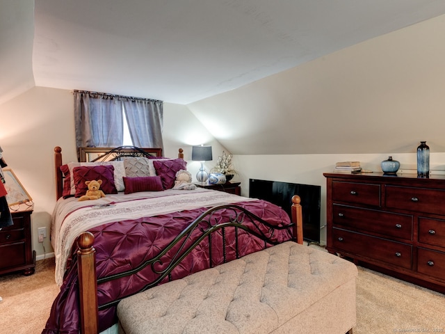 bedroom featuring light carpet and lofted ceiling