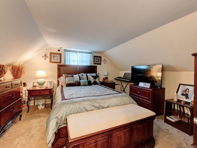 bedroom featuring light colored carpet and vaulted ceiling