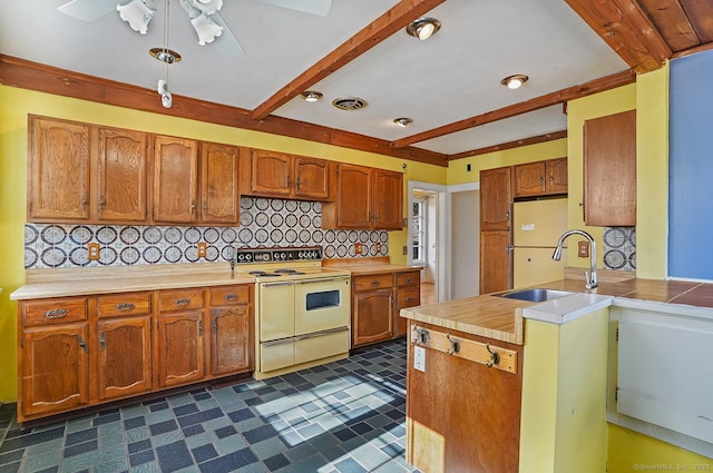 kitchen featuring double oven range, visible vents, a sink, beamed ceiling, and tasteful backsplash