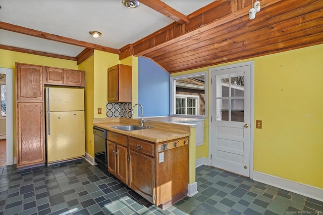 kitchen featuring baseboards, light countertops, black dishwasher, freestanding refrigerator, and a sink