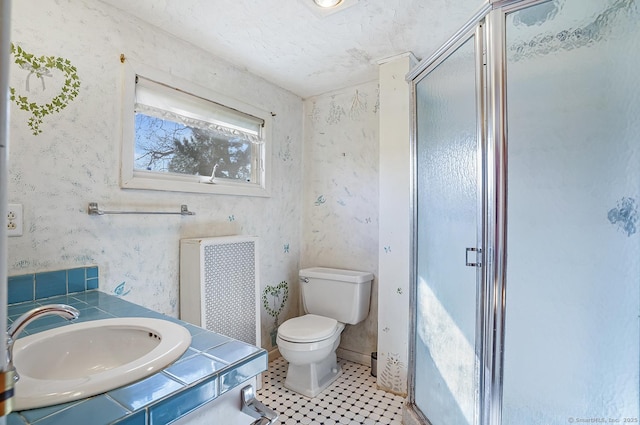 full bath featuring toilet, radiator heating unit, a shower stall, wallpapered walls, and vanity