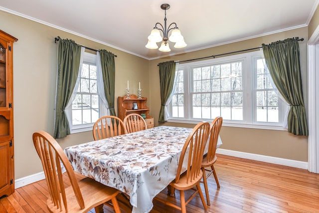 dining space featuring a chandelier, light wood-type flooring, baseboards, and ornamental molding