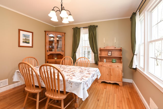 dining room with crown molding, a notable chandelier, and baseboards