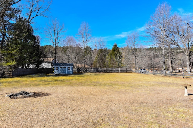 view of yard featuring a shed, an outdoor structure, and a fenced backyard