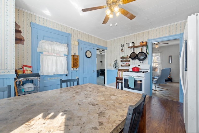 dining room with wallpapered walls, crown molding, and wainscoting