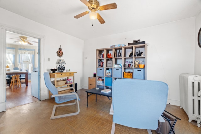 home office with parquet floors, radiator heating unit, a ceiling fan, and baseboards