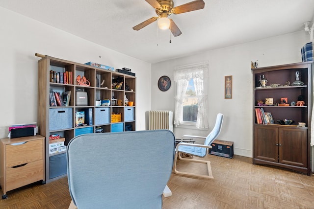 home office featuring baseboards, radiator heating unit, and a ceiling fan