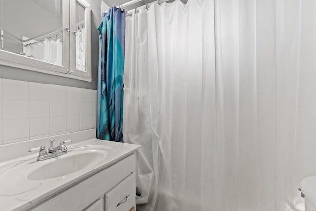 bathroom featuring vanity, a shower with shower curtain, and tile walls