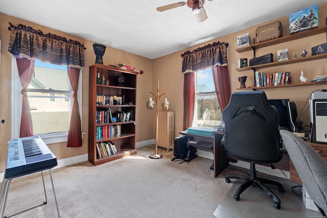 carpeted office featuring radiator heating unit, a ceiling fan, and baseboards