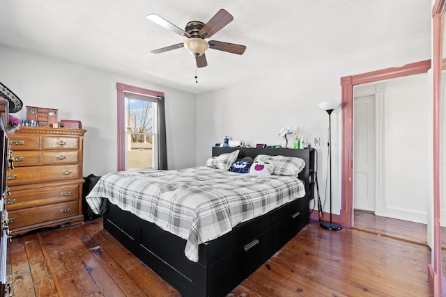 bedroom featuring baseboards, a ceiling fan, and dark wood-style flooring