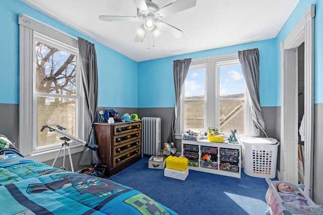 bedroom featuring a ceiling fan, radiator, and carpet flooring