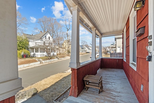 wooden terrace with a residential view and covered porch