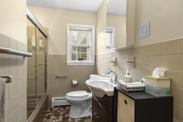 full bathroom with a wainscoted wall, toilet, tile walls, baseboard heating, and vanity