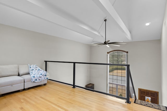 unfurnished room with lofted ceiling with beams, an upstairs landing, wood finished floors, and ceiling fan