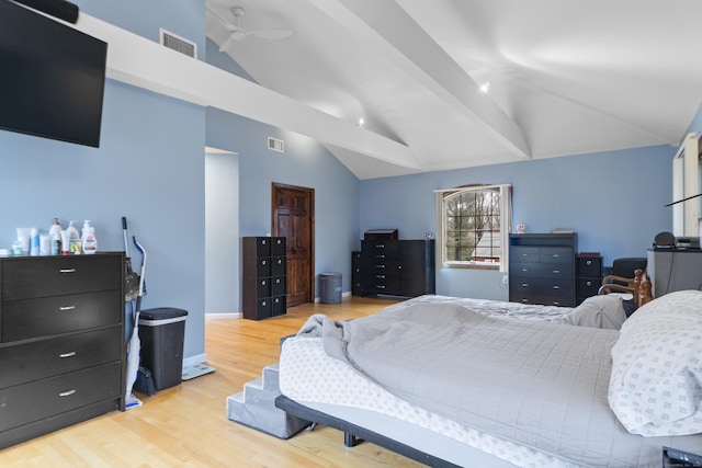 bedroom featuring visible vents, light wood-style flooring, and vaulted ceiling with beams