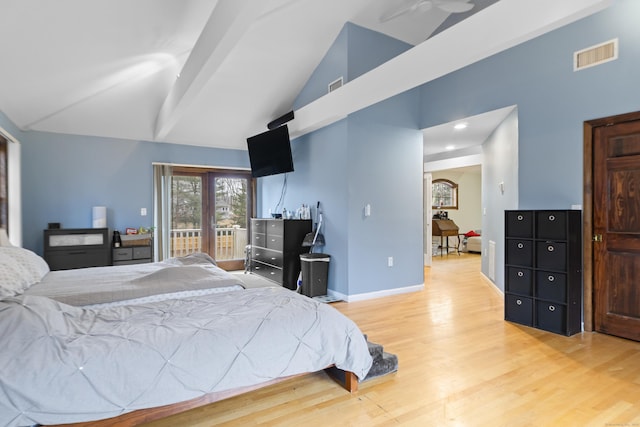 bedroom featuring lofted ceiling, light wood-style floors, visible vents, and baseboards