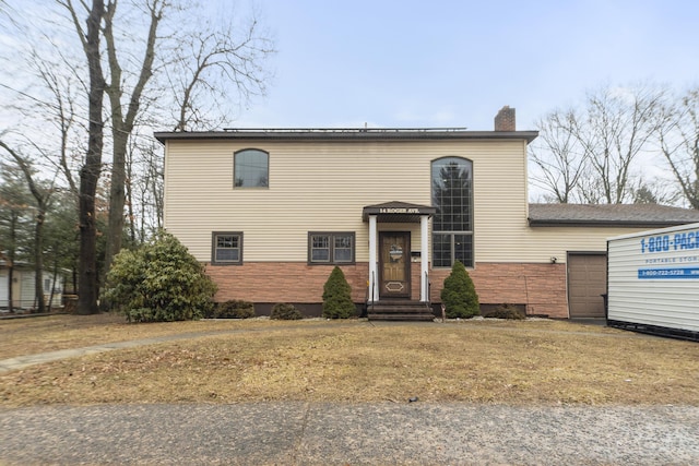 traditional-style house with stone siding and a chimney