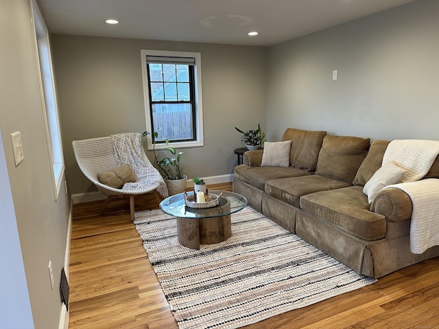 living room featuring recessed lighting, baseboards, and light wood-style flooring