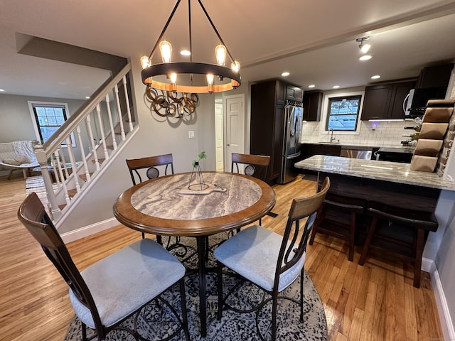 dining space featuring recessed lighting, baseboards, light wood-style floors, and stairs