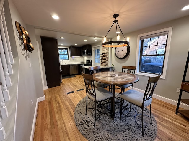 dining room with light wood finished floors, recessed lighting, and baseboards