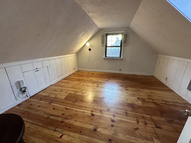 additional living space featuring vaulted ceiling and wood-type flooring