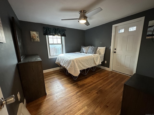 bedroom with a ceiling fan, baseboards, and dark wood-style flooring