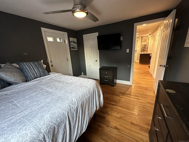 bedroom featuring a closet, baseboards, light wood-style floors, and a ceiling fan