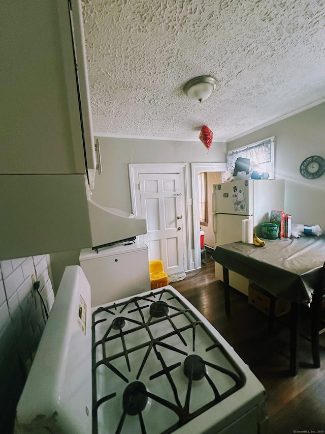 kitchen with a textured ceiling, wood finished floors, and freestanding refrigerator