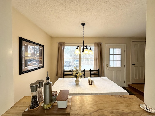 dining area featuring a notable chandelier and a textured ceiling