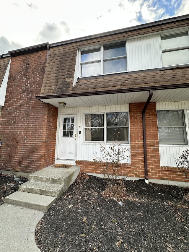 view of exterior entry featuring brick siding