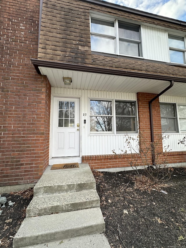 entrance to property featuring brick siding