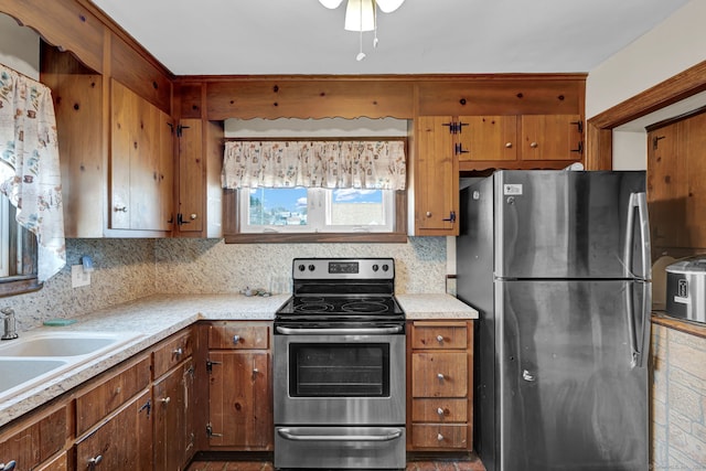 kitchen featuring light countertops, tasteful backsplash, appliances with stainless steel finishes, and brown cabinets