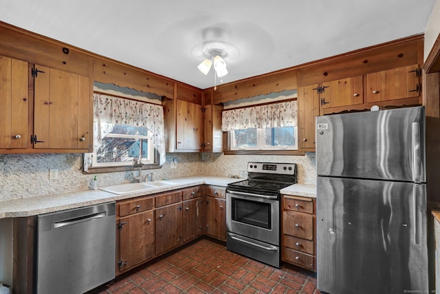 kitchen featuring a sink, light countertops, decorative backsplash, and stainless steel appliances