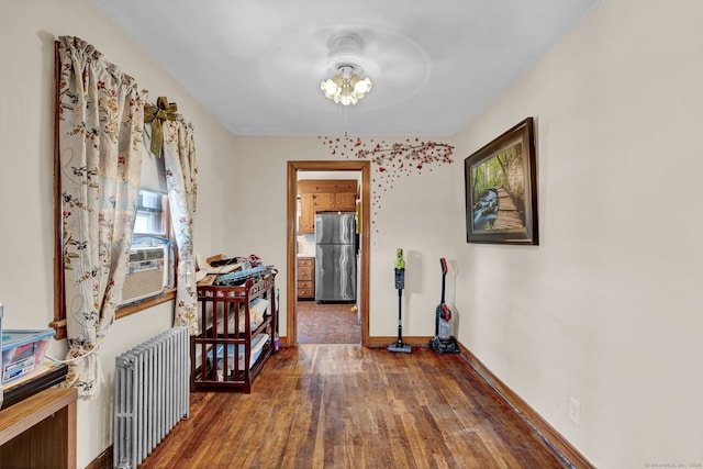 hall featuring cooling unit, radiator heating unit, baseboards, and wood finished floors