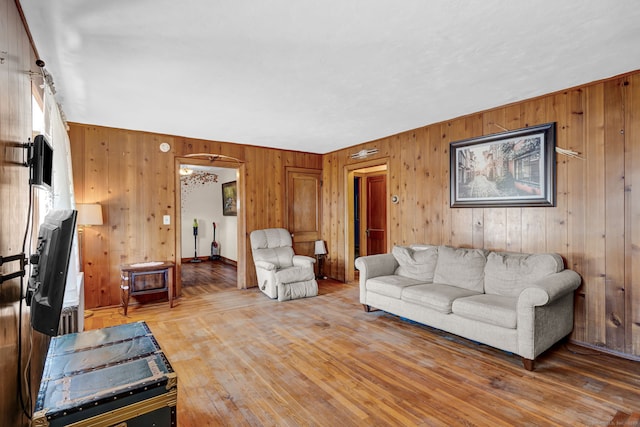 living room featuring hardwood / wood-style flooring and wooden walls