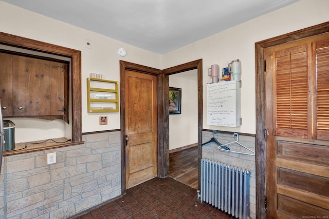 interior space featuring brick floor and radiator