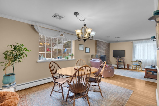 dining room with ornamental molding, a brick fireplace, a baseboard heating unit, and wood finished floors