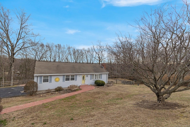 view of front of property featuring aphalt driveway, a front lawn, and fence