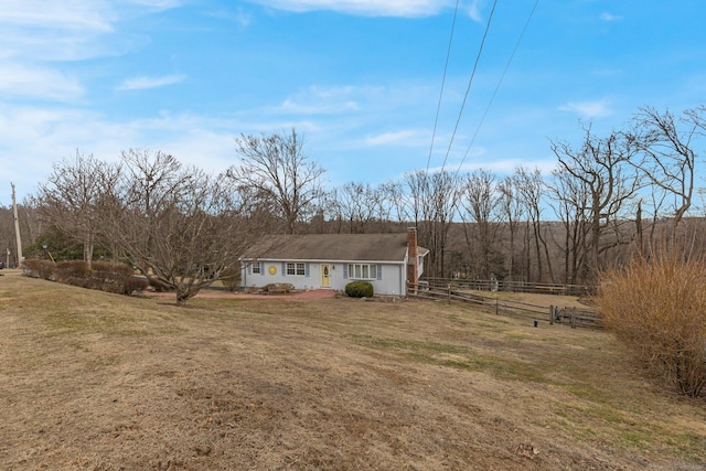 view of front facade featuring a front yard and fence