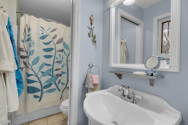 bathroom with tile patterned floors, toilet, and a sink