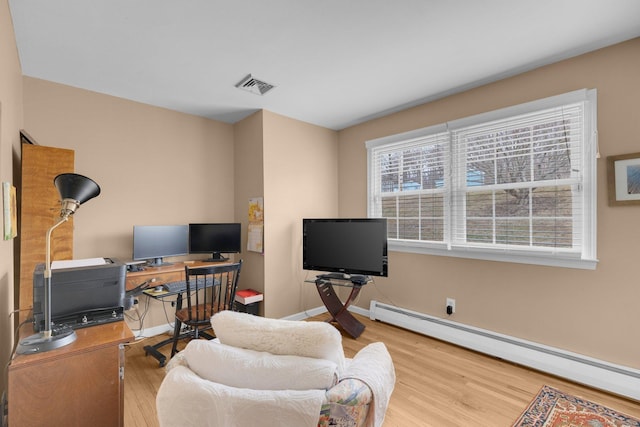 living area with visible vents, wood finished floors, baseboards, and a baseboard radiator