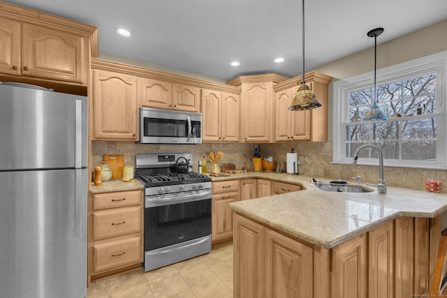 kitchen with a sink, stainless steel appliances, a peninsula, and light brown cabinetry