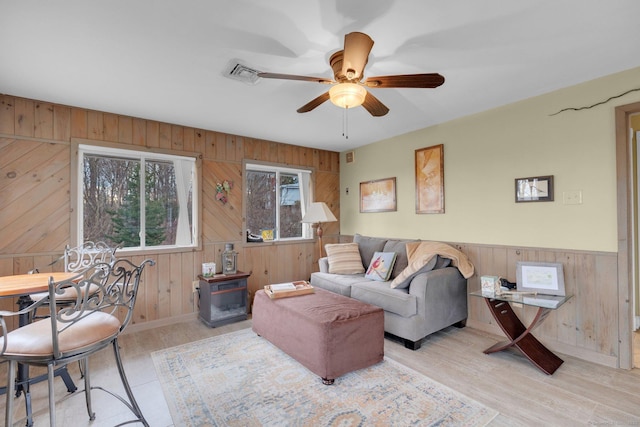 living room featuring visible vents, a ceiling fan, and light wood finished floors